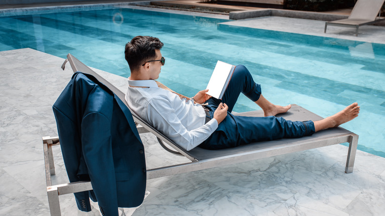 man reading by the pool