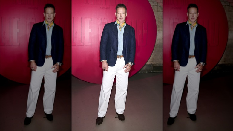 Matthew Davis in a navy suit Jacket and white pants