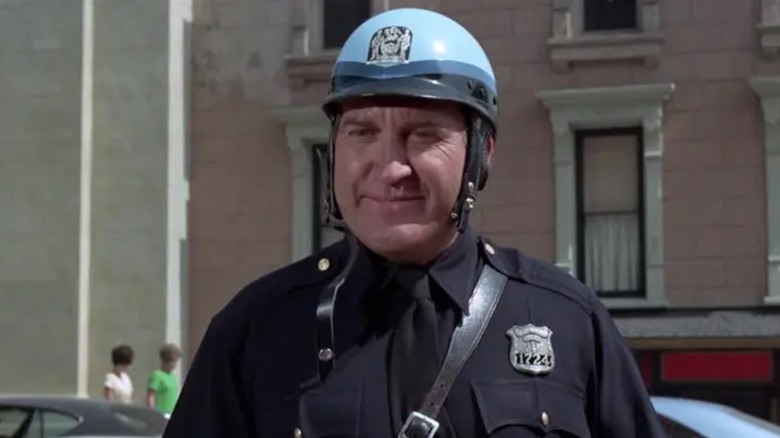 A 1960s police officer wearing a helmet and smiling
