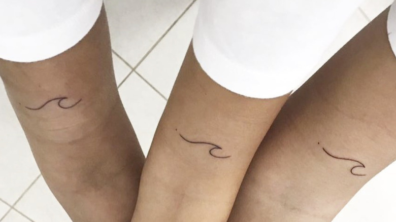 Minimalist sun and wave tattoo on the ankle