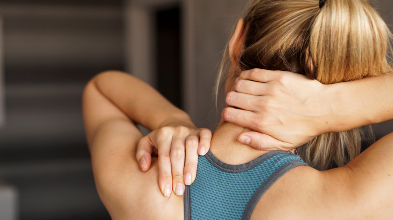 Woman touching her neck and back