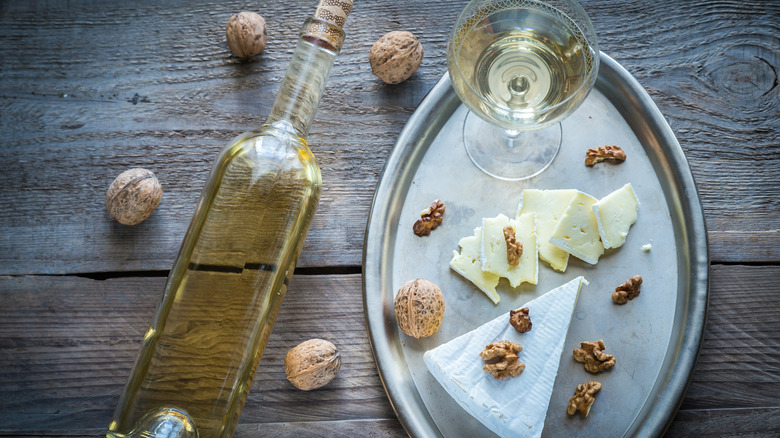Wine bottle with cheese plate and wine glass