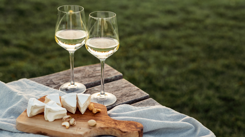 Glasses of wine next to a platter of cheese