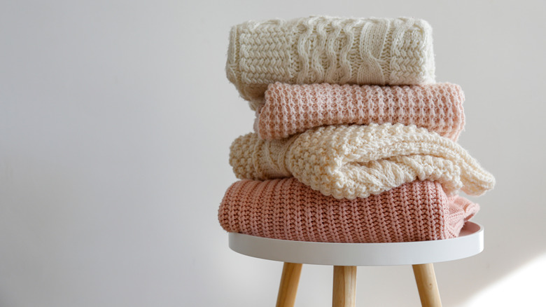 Pastel sweaters stacked on table