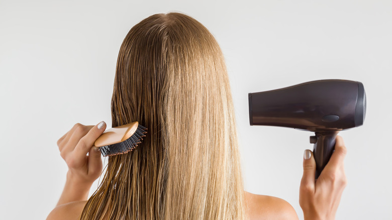 Blonde woman drying her hair