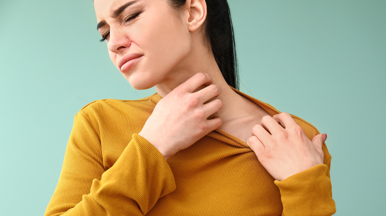 A woman scratching her neck