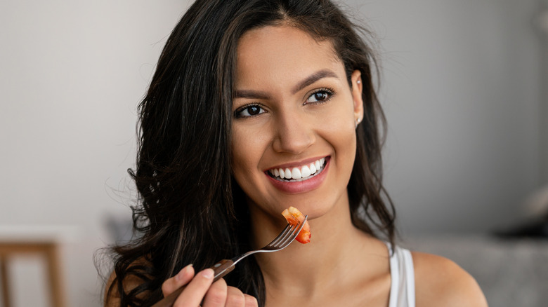 Woman eating a vegetable 