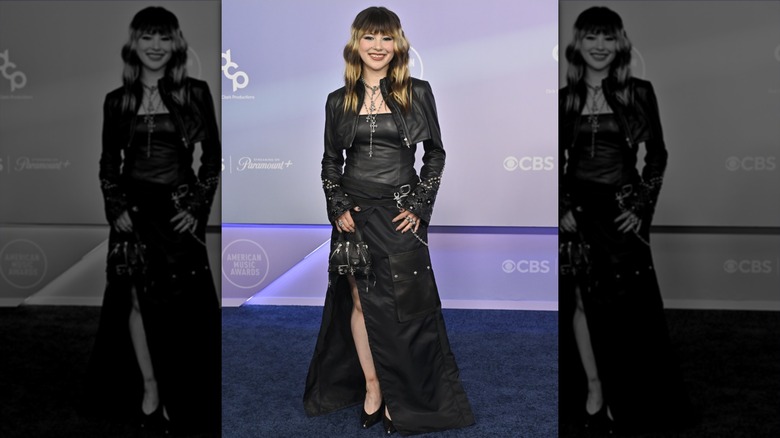Alysa Liu smiling in a black outfit on the red carpet of the 2026 AMAs