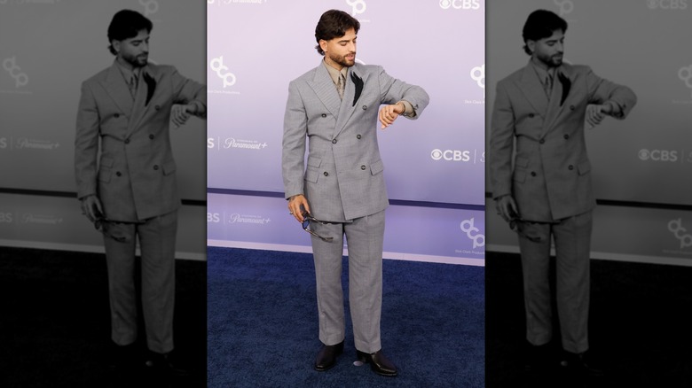 Maluma checking his watch on the red carpet of the 2026 AMAs