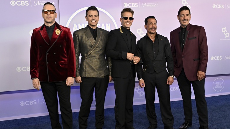 New Kids on the Block smiling on the red carpet of the 2026 AMAs