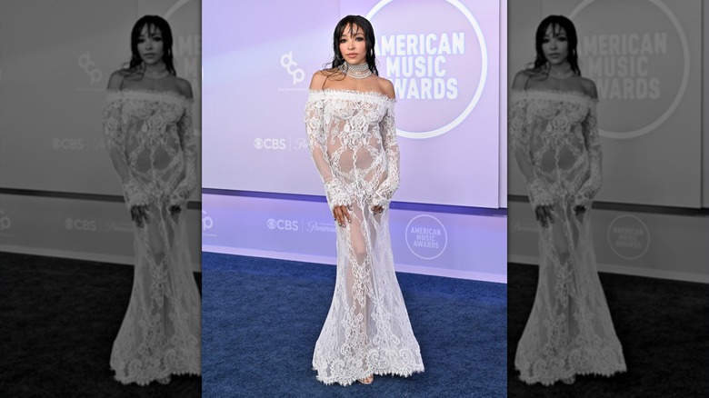 Tinashe in a white lace dress, posing for a photo at the 2026 AMAs