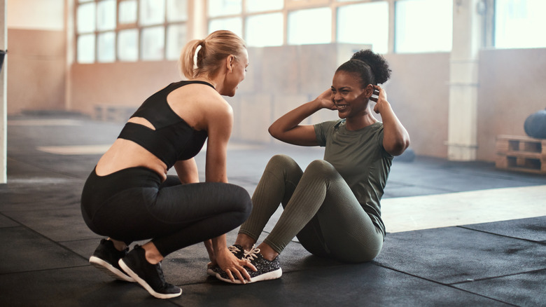 Two women doing sit ups at the gym together