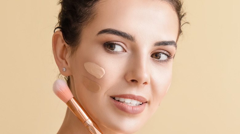 woman applying foundation with makeup brush
