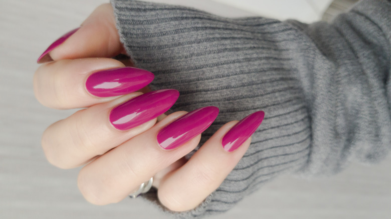 long pink nails over gray sweater