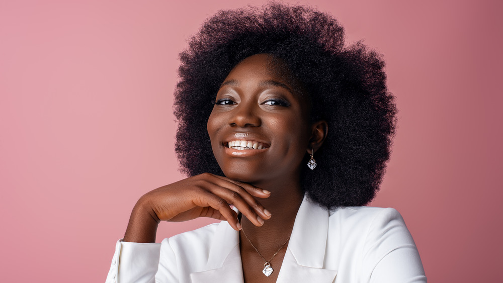 Smiling Black woman wearing white gold jewelry