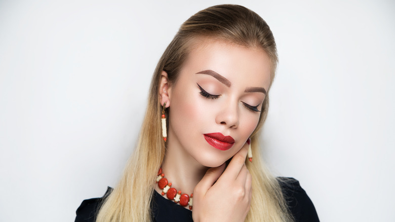 Woman with oval face showing off necklace
