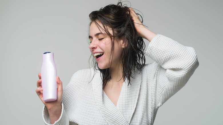 Woman holding conditioner bottle