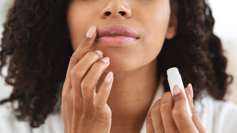 Woman applying lip balm