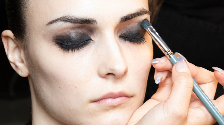 Model getting smokey eyeshadow applied