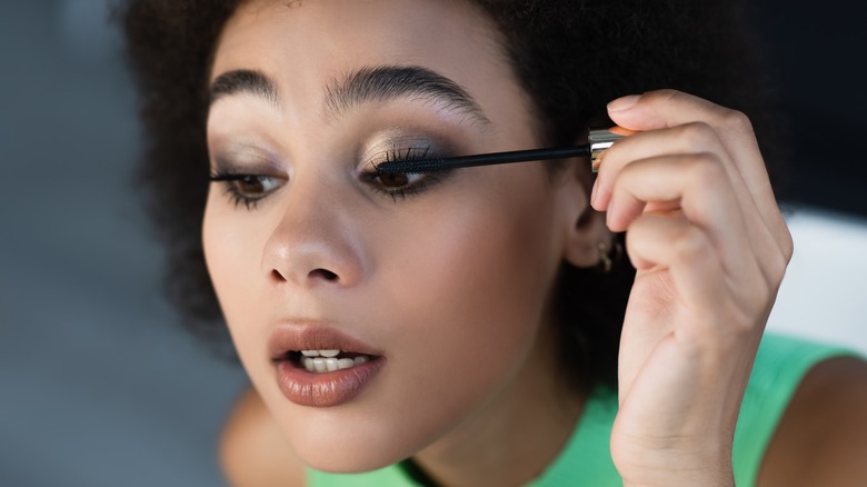 Woman applying mascara