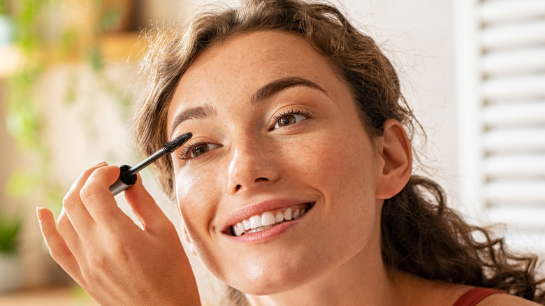 Woman applying mascara