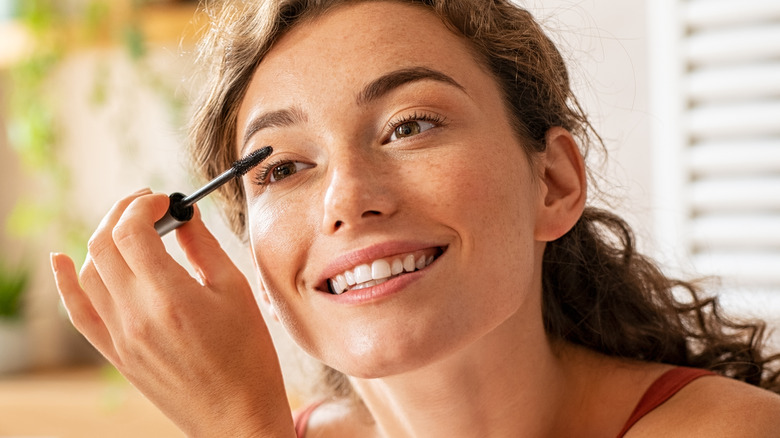 Woman putting on mascara