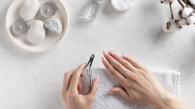 close up of hands clipping nails with nail clipper