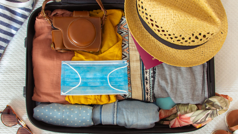Mask sitting on open suitcase