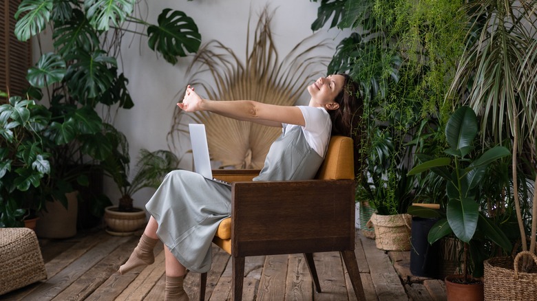 Woman sitting surrounded by plants