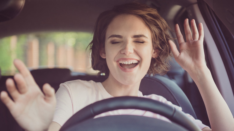 Woman driving and listening to entertaining media