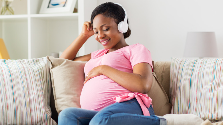 Pregnant woman listening to podcast