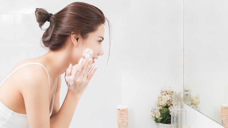Woman cleansing face