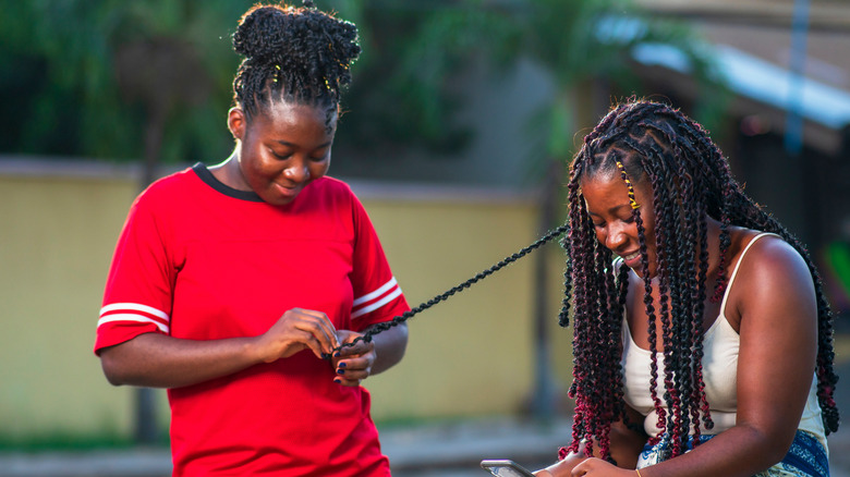 girl braiding other girls hair 