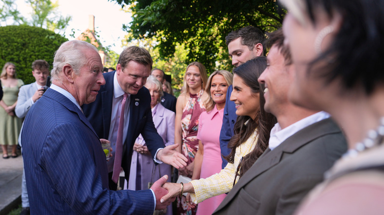 King Charles III shaking Kaitlan Collins' hand