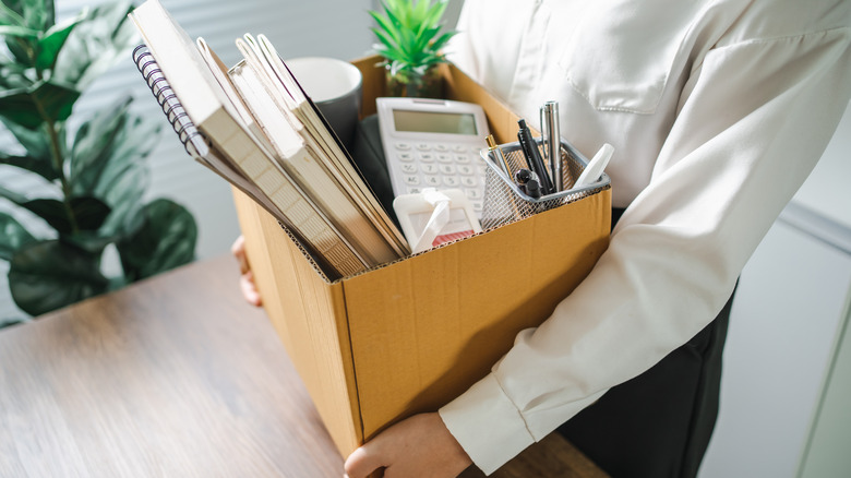 person holding box with office belongings
