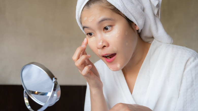 Woman applying lightweight foundation on skin