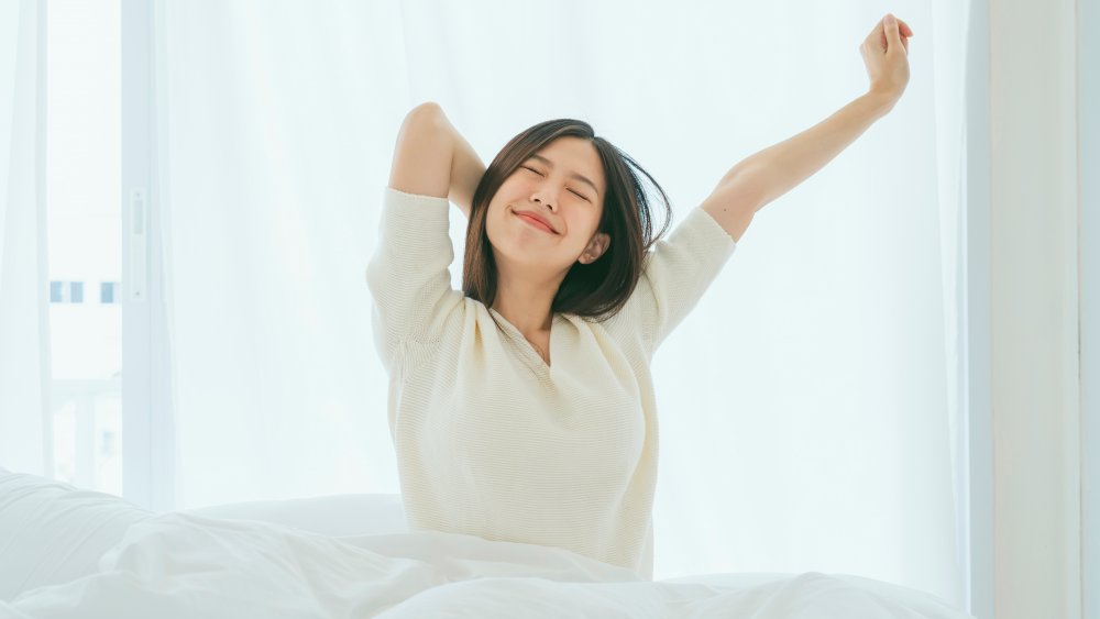 Woman stretching in bed