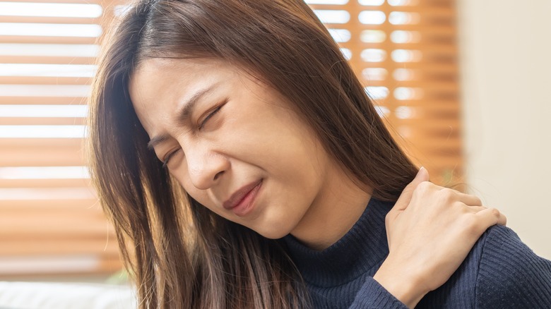 Woman holding shoulder in pain