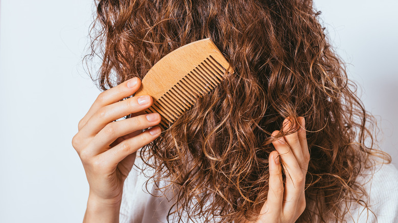 Woman combing her curly hair