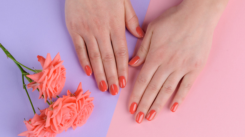 Hands with coral nail polish
