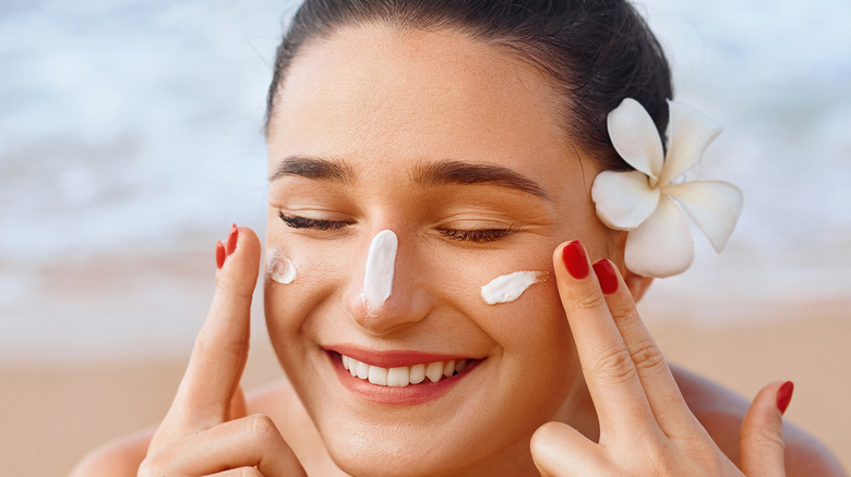 Woman applying sunscreen to her face