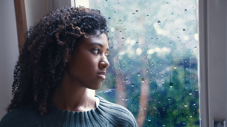 Woman feeling depressed while watching the rain