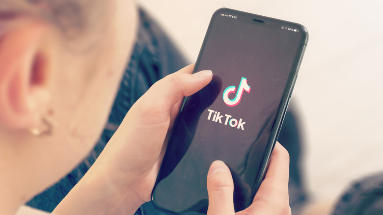 A woman loading TikTok on her phone