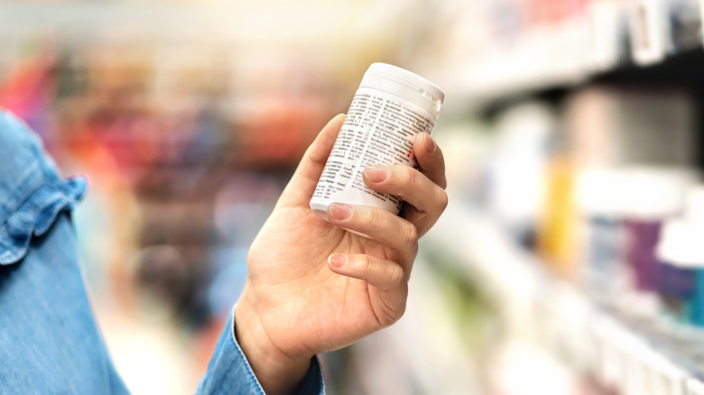 Woman holding vitamins in store