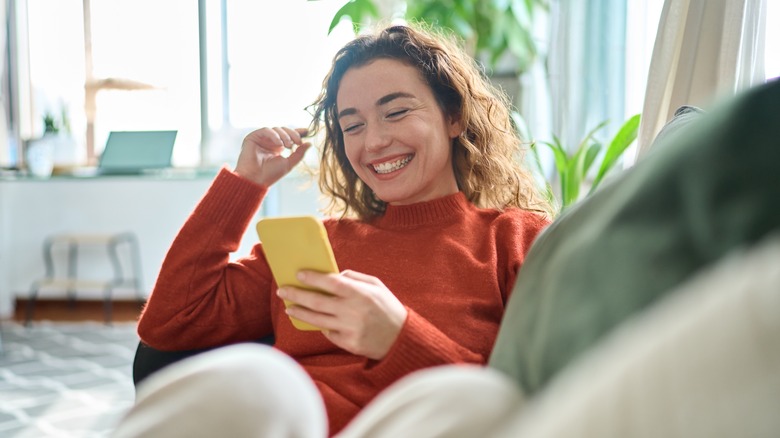 Woman laughing looking at phone