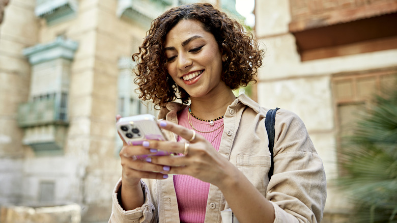 Smiling woman using phone