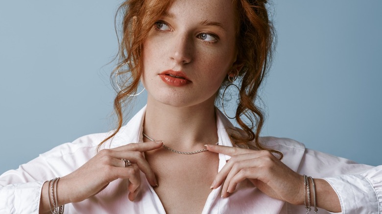 Woman wears silver necklace, hoop earrings and bracelets