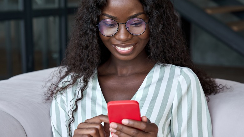 Woman using app on red cell phone 
