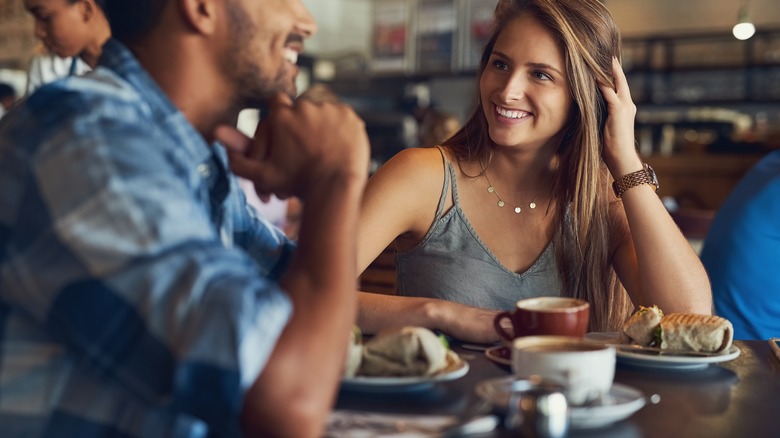 Man and woman smile at each other during a date