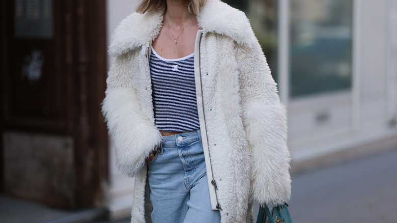 white fur coat over jeans